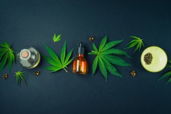 Medical CBD oil on black modern background with hemp leaves. Medical marijuana tincture concept.