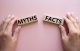 Símbolo de factos ou mitos. O conceito da palavra Factos ou Mitos em blocos de madeira sobre um fundo cor-de-rosa